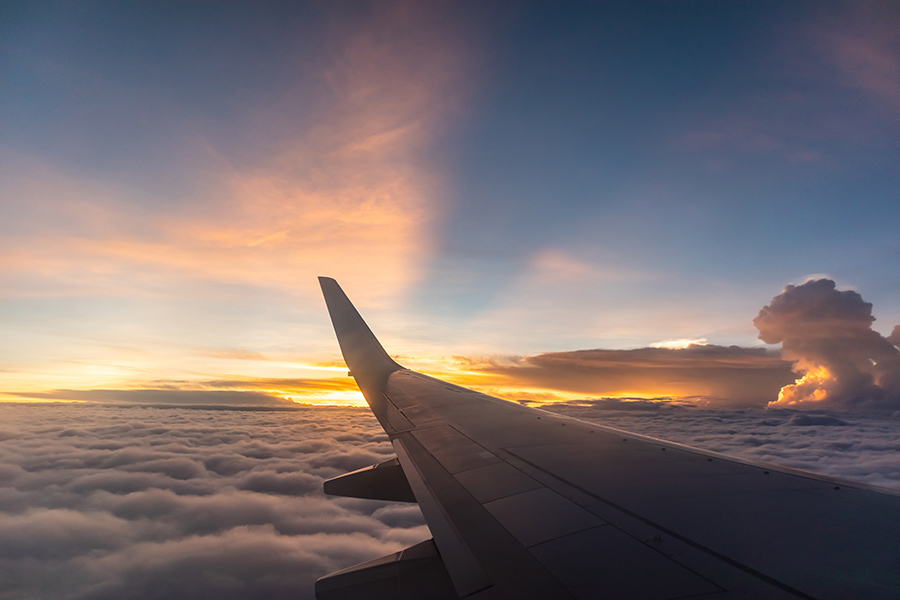 wing of an airplane, in the sky, overlooking clouds