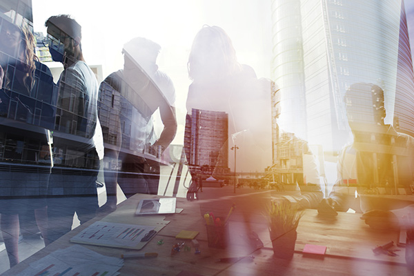 silhouette of a group of business people, with a city on top of them