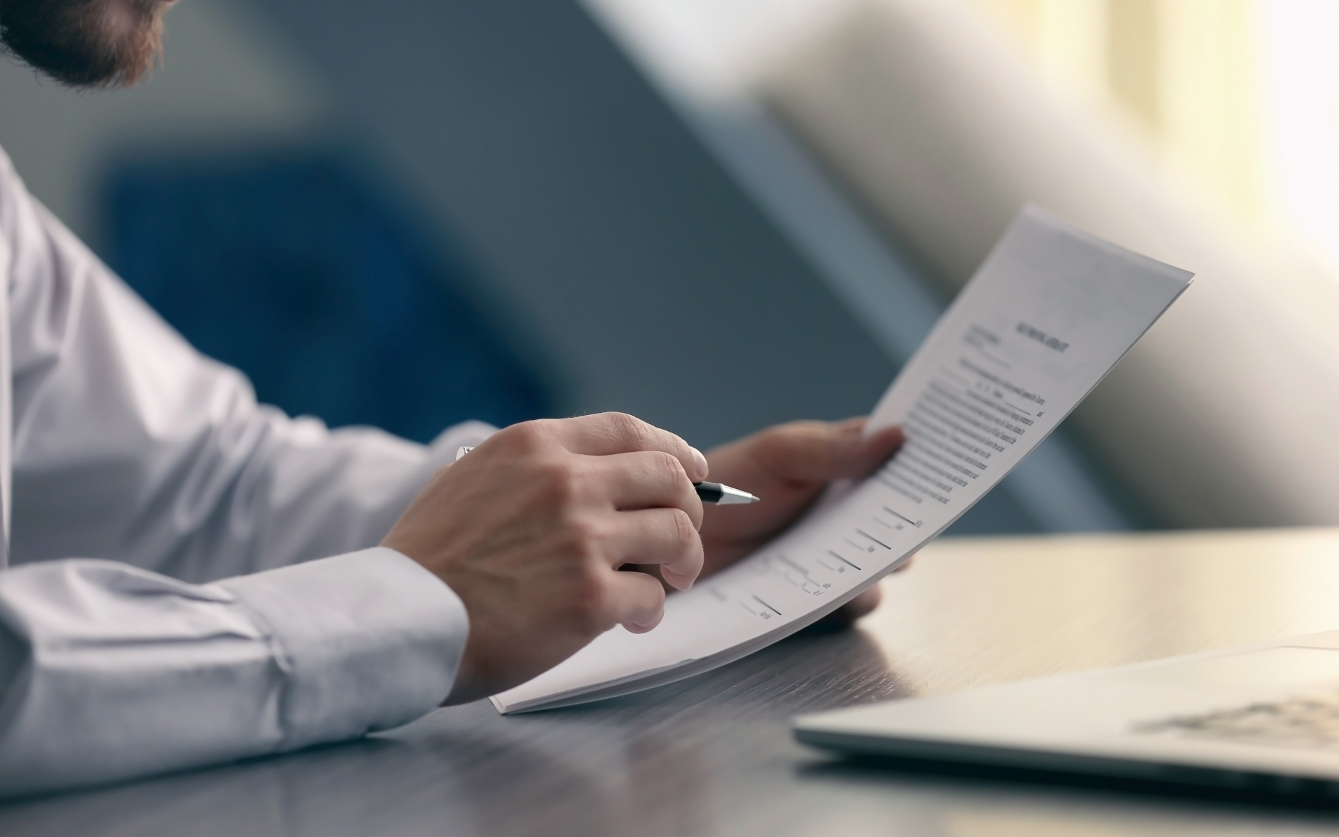 closeup of man reviewing piece of paper with data on it