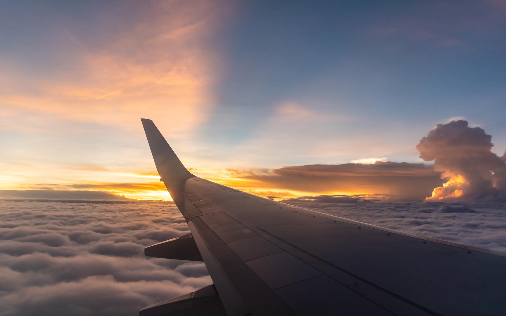 a view of an airplane flying over the cloud