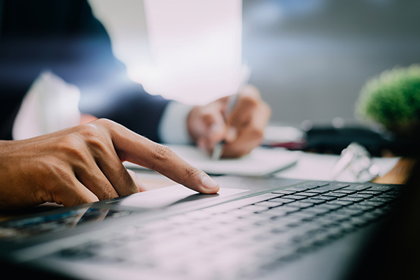 person moving their finger on a trackpad for a laptop computer