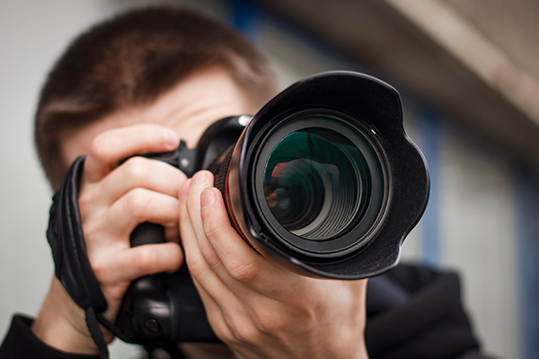 close up of an investigator taking a picture with a professional camera