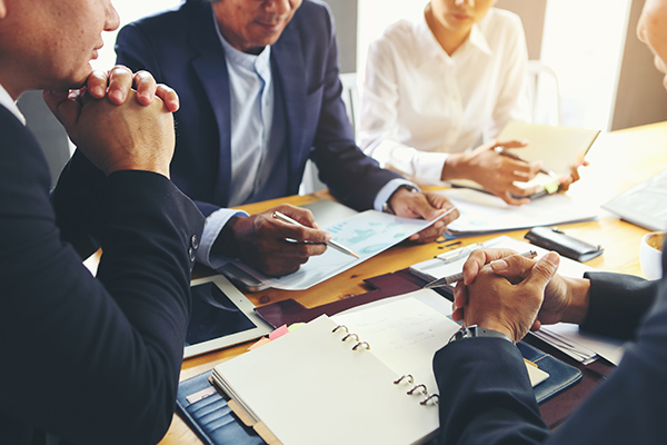 business executives sitting at a conference table reviewing papers