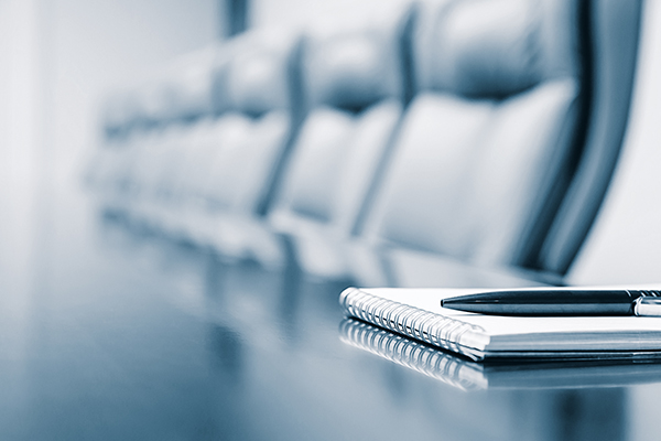 a notebook and pen sitting on the top of a conference table